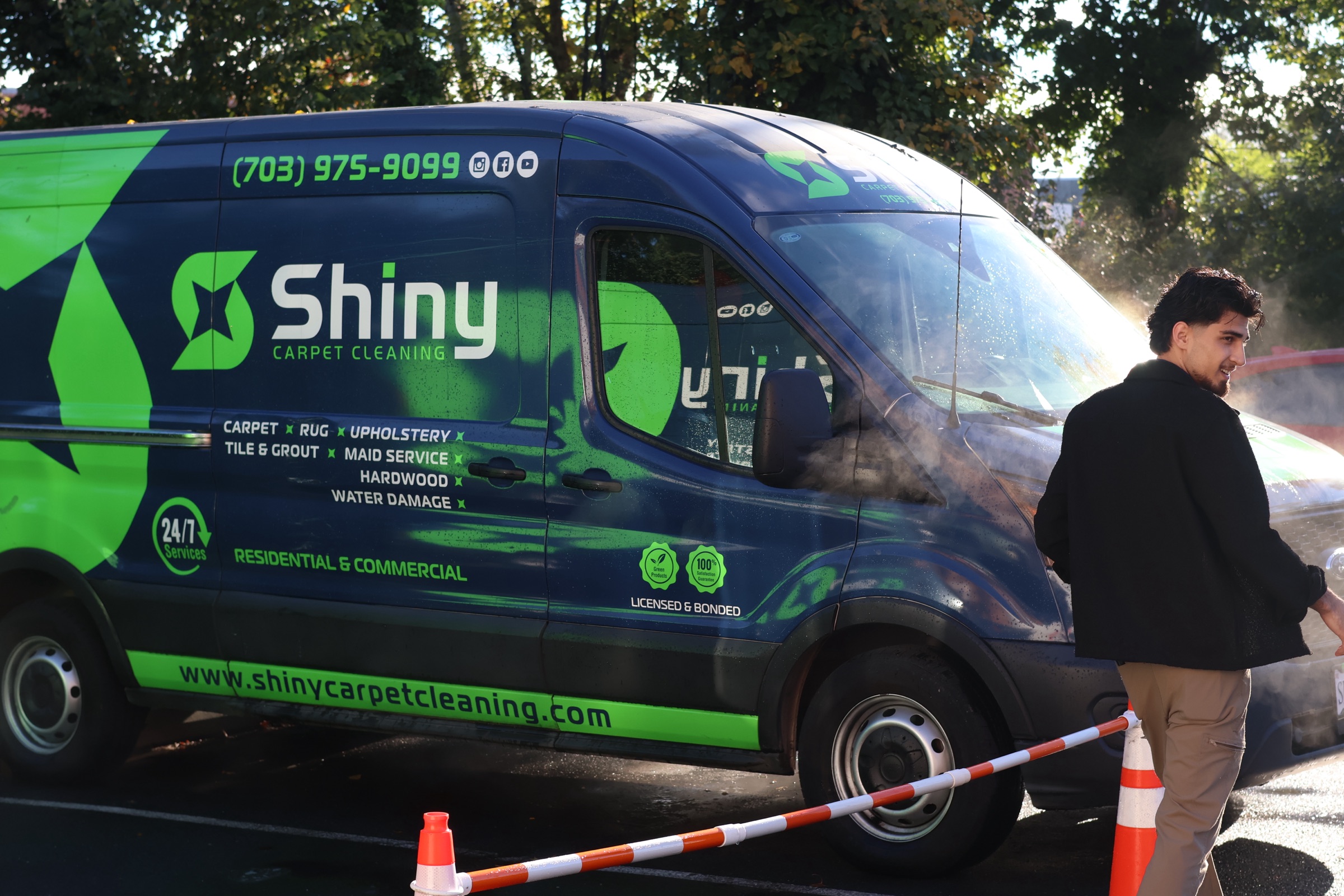 A Shiny team member beside a branded carpet cleaning van